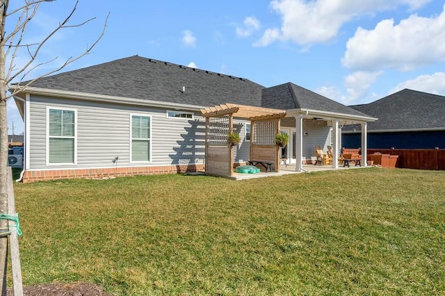 back of house with a yard, a patio, a shingled roof, and a pergola