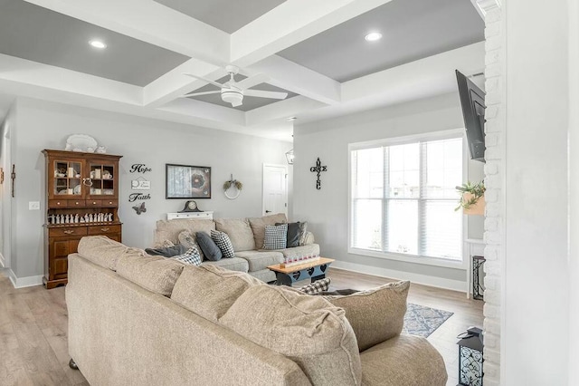 living room with a ceiling fan, baseboards, coffered ceiling, beam ceiling, and light wood-style flooring