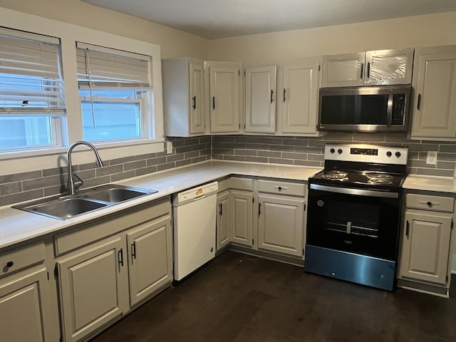 kitchen featuring a sink, decorative backsplash, appliances with stainless steel finishes, and light countertops