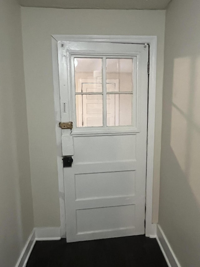 doorway featuring baseboards