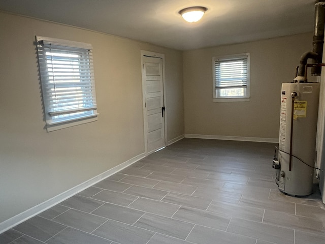 below grade area featuring baseboards and water heater