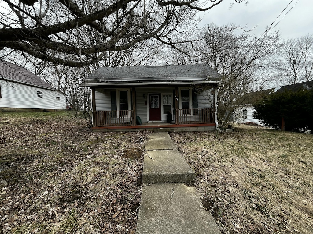 bungalow with a porch and roof with shingles