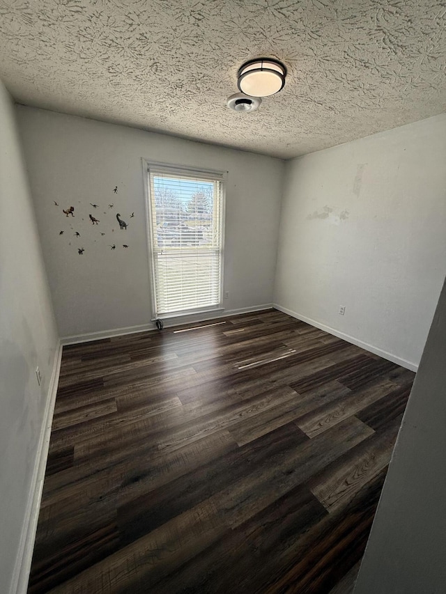 unfurnished room with dark wood finished floors, visible vents, a textured ceiling, and baseboards