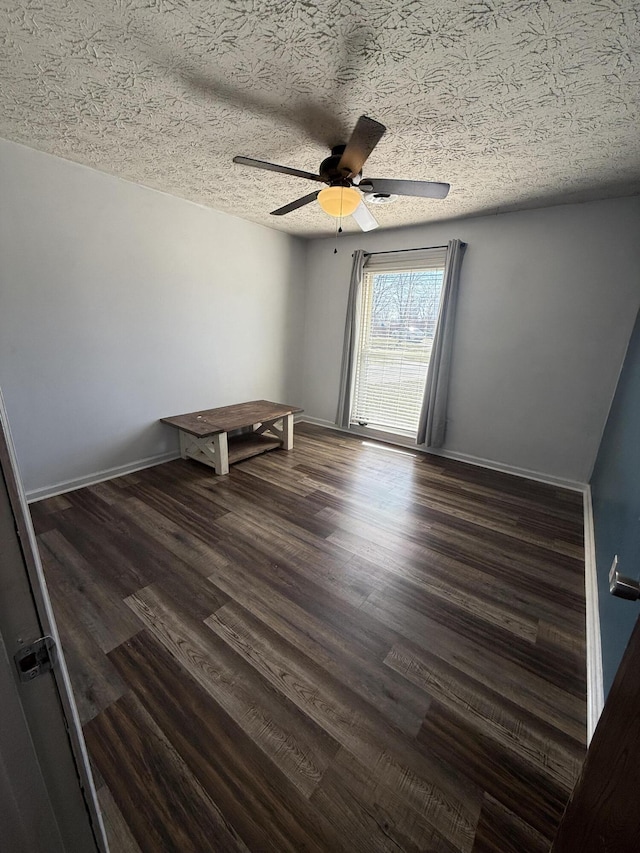 unfurnished room with baseboards, a textured ceiling, wood finished floors, and a ceiling fan