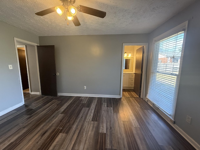 unfurnished bedroom featuring ceiling fan, dark wood-type flooring, baseboards, and a textured ceiling