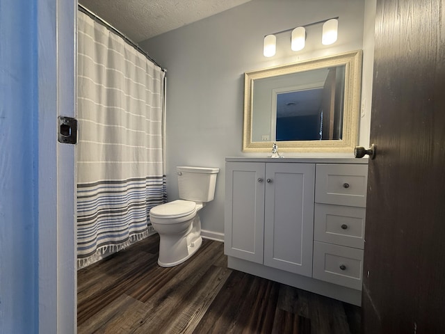 full bathroom with vanity, wood finished floors, baseboards, a textured ceiling, and toilet