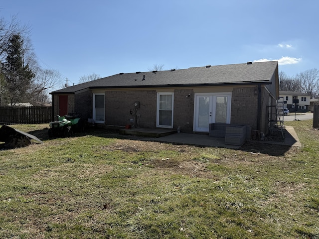 back of property featuring brick siding, fence, french doors, a yard, and a patio area