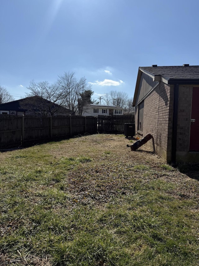 view of yard with central AC and fence