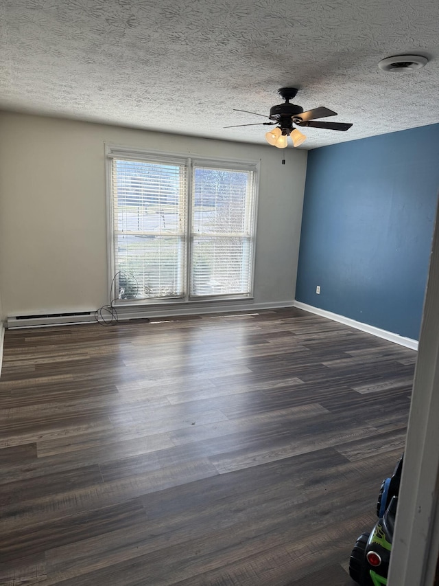 spare room with ceiling fan, dark wood-type flooring, baseboards, and a textured ceiling