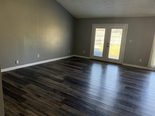 spare room featuring a textured ceiling, french doors, dark wood-style flooring, and baseboards