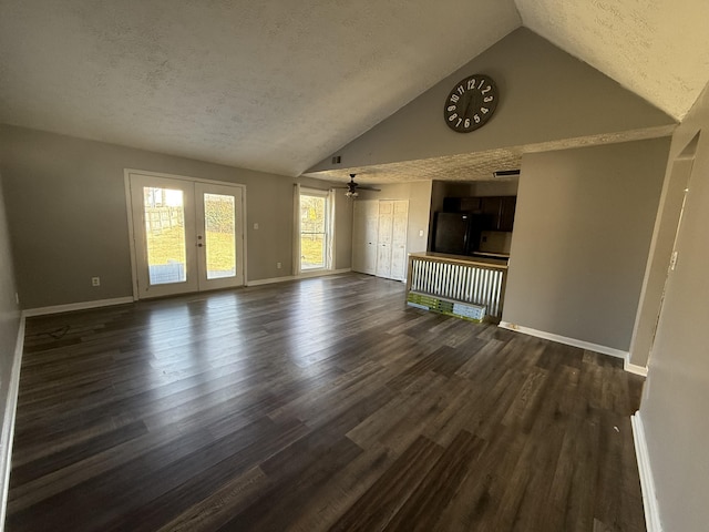 unfurnished living room with a textured ceiling, french doors, dark wood-style flooring, and baseboards