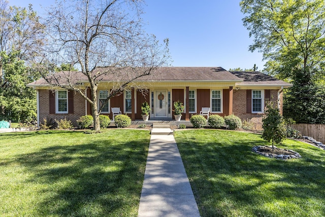 ranch-style home featuring a front yard, fence, and brick siding