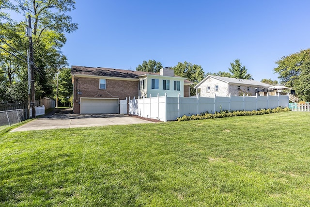 view of front of home with a front yard, fence, driveway, an attached garage, and brick siding