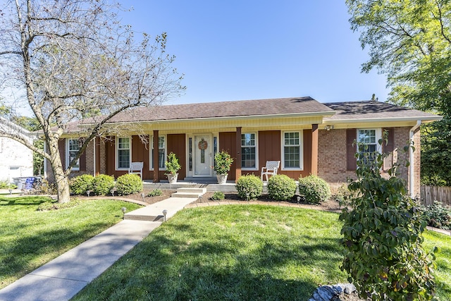 ranch-style home with board and batten siding, a front lawn, covered porch, and brick siding