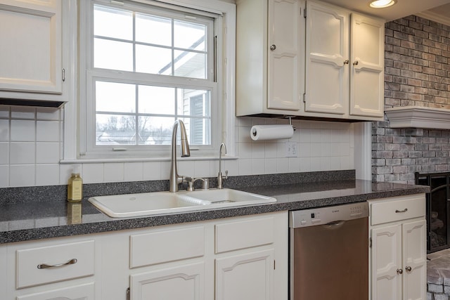 kitchen with a sink, backsplash, dishwasher, and white cabinetry