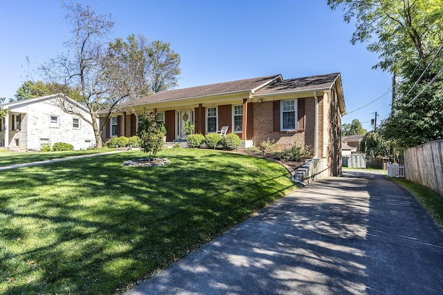 view of front of home with driveway, fence, cooling unit, a front yard, and brick siding