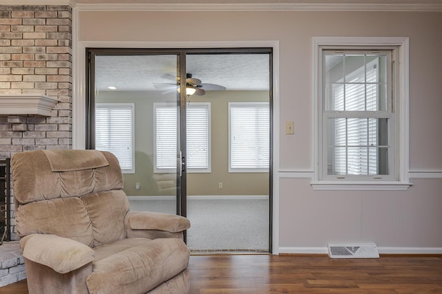 sitting room with visible vents, plenty of natural light, baseboards, and wood finished floors