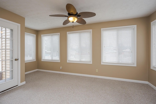 spare room with plenty of natural light, baseboards, and a textured ceiling