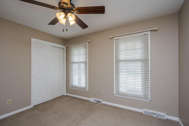 unfurnished bedroom with a closet, visible vents, carpet flooring, and baseboards