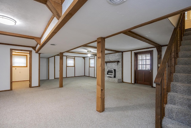 basement with stairway, heating unit, a textured ceiling, and carpet flooring