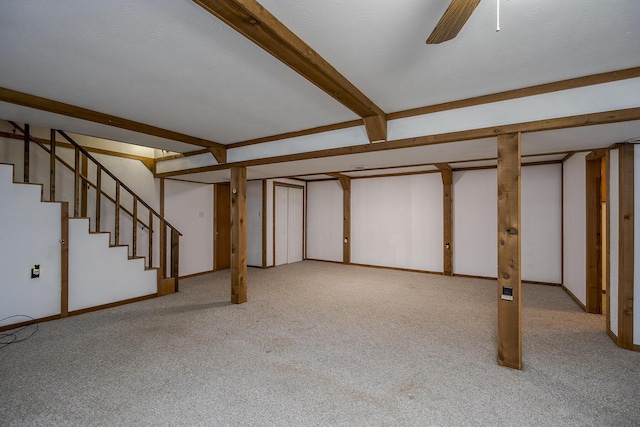 finished basement with carpet, stairway, a ceiling fan, and baseboards