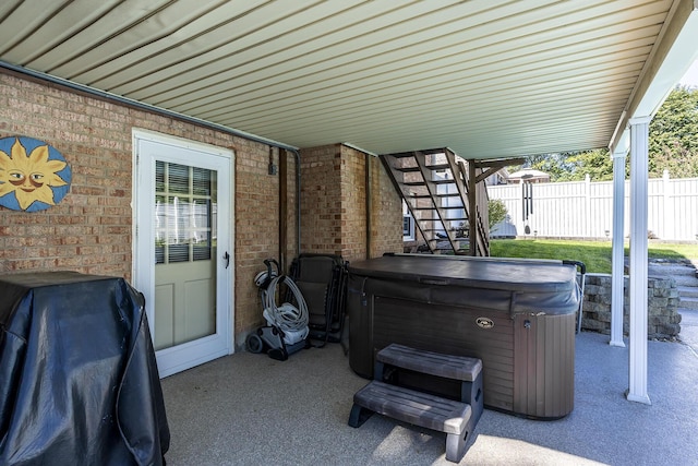 view of patio / terrace featuring stairway, fence, area for grilling, and a hot tub