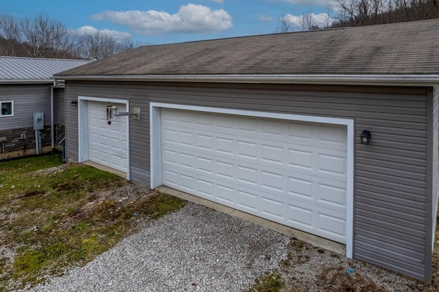 garage with gravel driveway