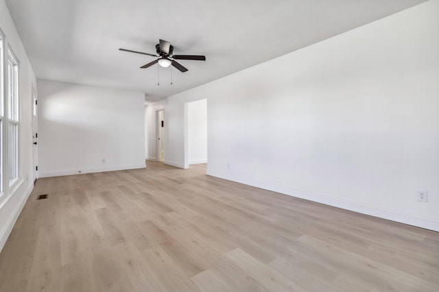 empty room with a ceiling fan, baseboards, visible vents, and light wood-type flooring