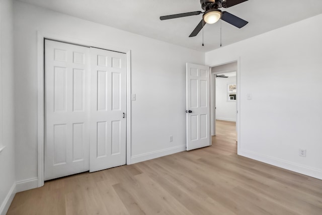 unfurnished bedroom with light wood-type flooring, baseboards, a closet, and ceiling fan