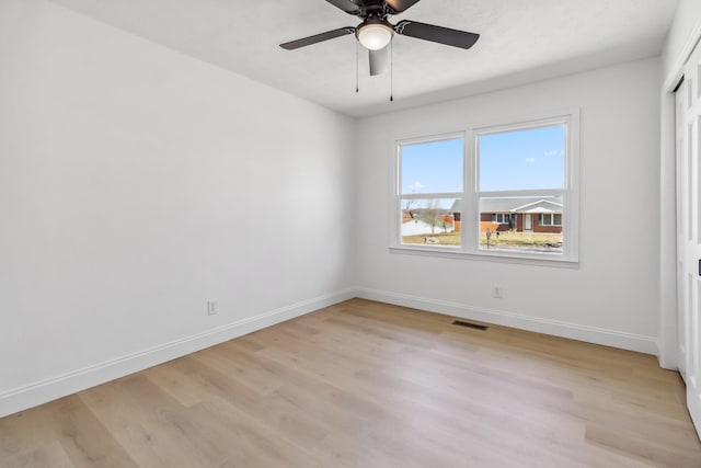 unfurnished bedroom featuring a ceiling fan, baseboards, visible vents, and light wood finished floors