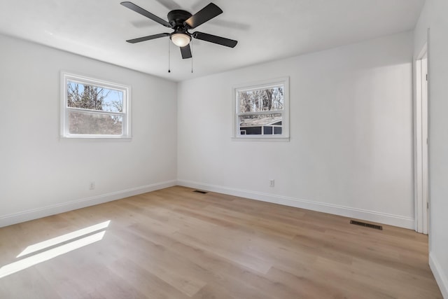 spare room with visible vents, baseboards, ceiling fan, and light wood finished floors