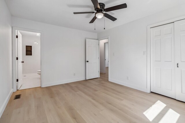 unfurnished bedroom featuring light wood finished floors, visible vents, ensuite bathroom, and baseboards