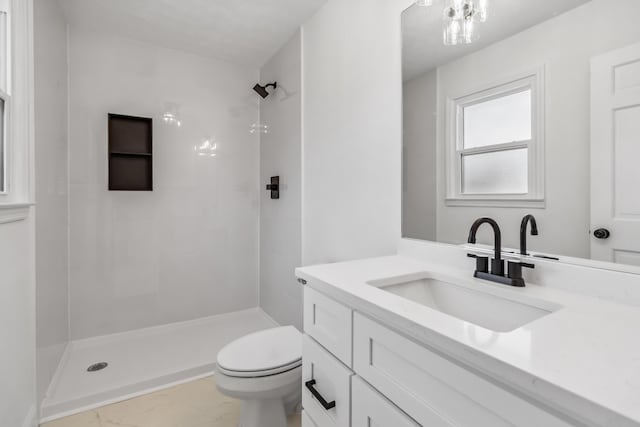 full bath with tiled shower, marble finish floor, toilet, and vanity