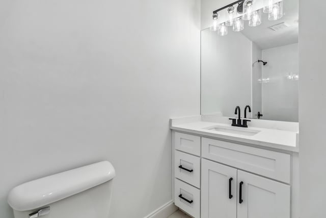 bathroom with vanity, toilet, a shower, and baseboards