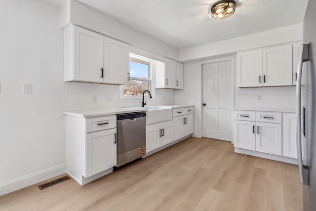 kitchen featuring visible vents, a sink, light countertops, appliances with stainless steel finishes, and light wood-type flooring