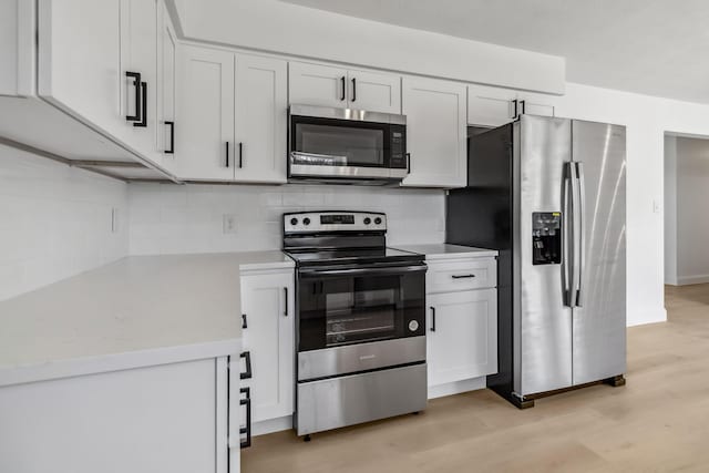 kitchen featuring stainless steel appliances, light wood-style floors, decorative backsplash, and light countertops