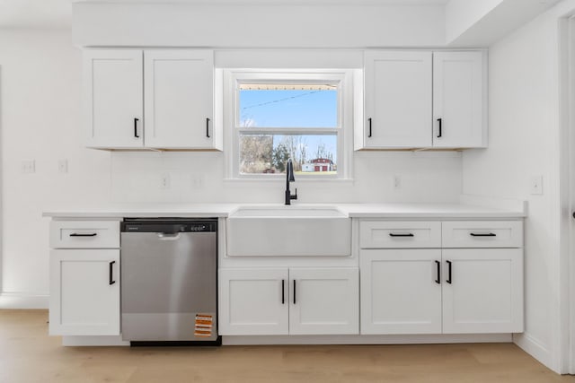 kitchen featuring a sink, dishwasher, white cabinets, and light countertops