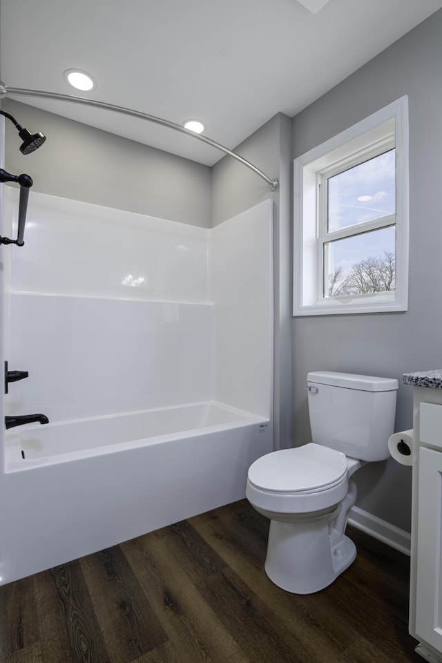 bathroom with tub / shower combination, toilet, wood finished floors, and vanity