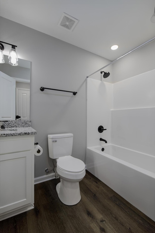 bathroom with visible vents, toilet, bathing tub / shower combination, wood finished floors, and vanity