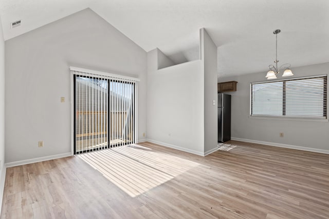 spare room featuring visible vents, baseboards, light wood-style floors, and a chandelier