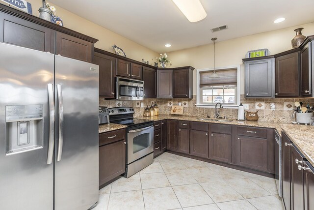 kitchen featuring tasteful backsplash, visible vents, appliances with stainless steel finishes, and a sink