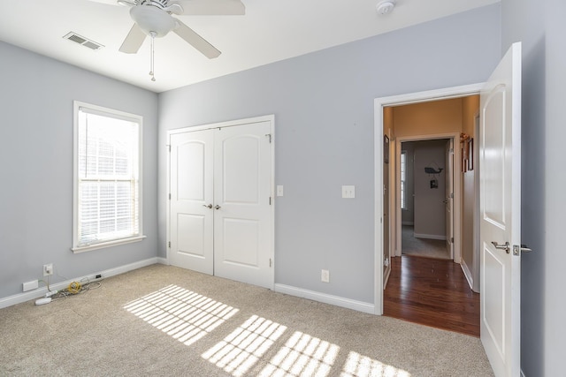 unfurnished bedroom featuring carpet flooring, baseboards, visible vents, and a closet