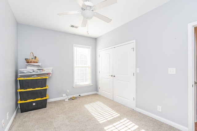 unfurnished bedroom with baseboards, visible vents, carpet floors, ceiling fan, and a closet