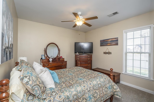 carpeted bedroom with visible vents, a ceiling fan, and baseboards