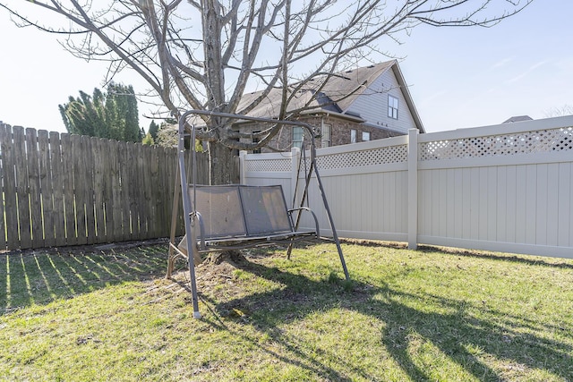 view of yard with a trampoline and a fenced backyard