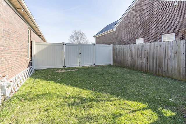 view of yard featuring a fenced backyard and a gate