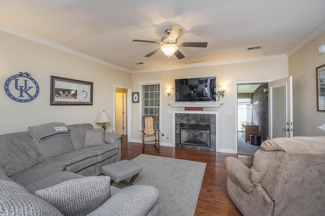 living room with visible vents, crown molding, baseboards, a fireplace, and dark wood-style floors