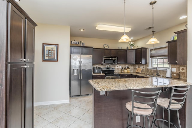 kitchen featuring visible vents, dark brown cabinetry, decorative backsplash, appliances with stainless steel finishes, and light tile patterned flooring