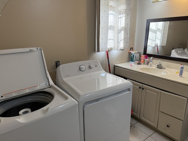 laundry area with a sink, separate washer and dryer, light tile patterned flooring, and laundry area