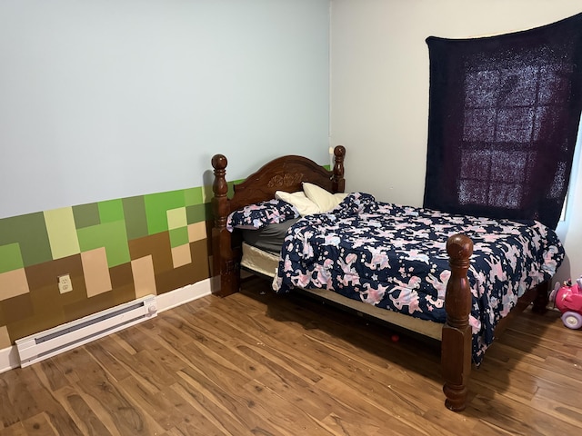 bedroom with baseboards, baseboard heating, and wood finished floors